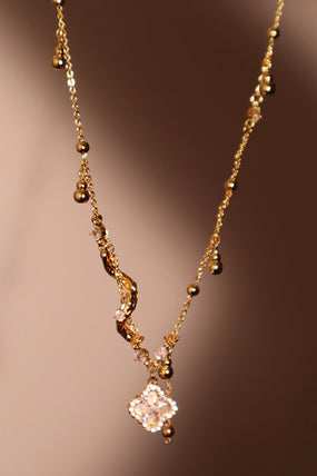 Gold-plated spiral necklace with lucky leaf motif, natural shell pearls and zirconia diamonds