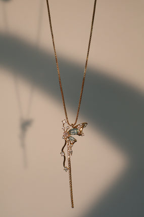 Gold-plated butterfly pendant necklace set with blue cubic zirconia gemstones on a fine chain
