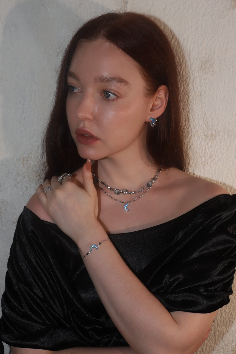 White gold moonstone set with crescent moon and star charms on a matching bracelet and necklace