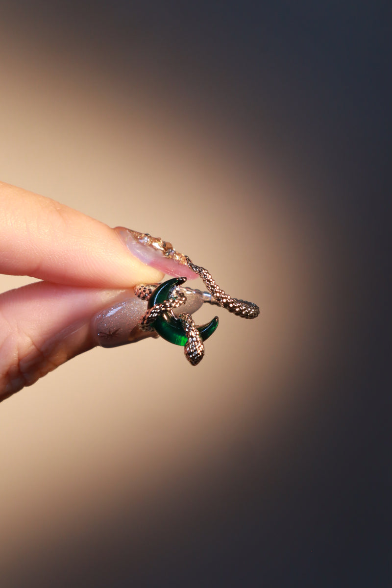 Silver-plated snake ring wrapped around a green zirconia moonstone, adjustable band