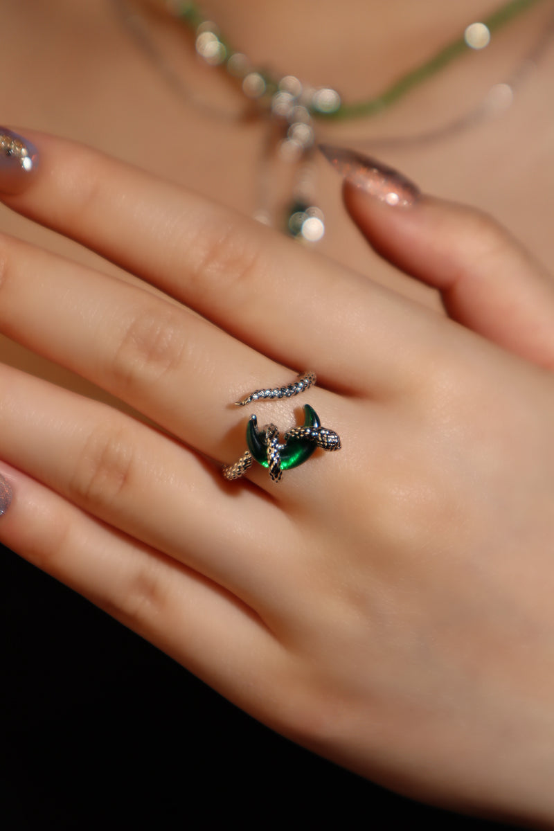 Silver-plated snake ring wrapped around a green zirconia moonstone, adjustable band