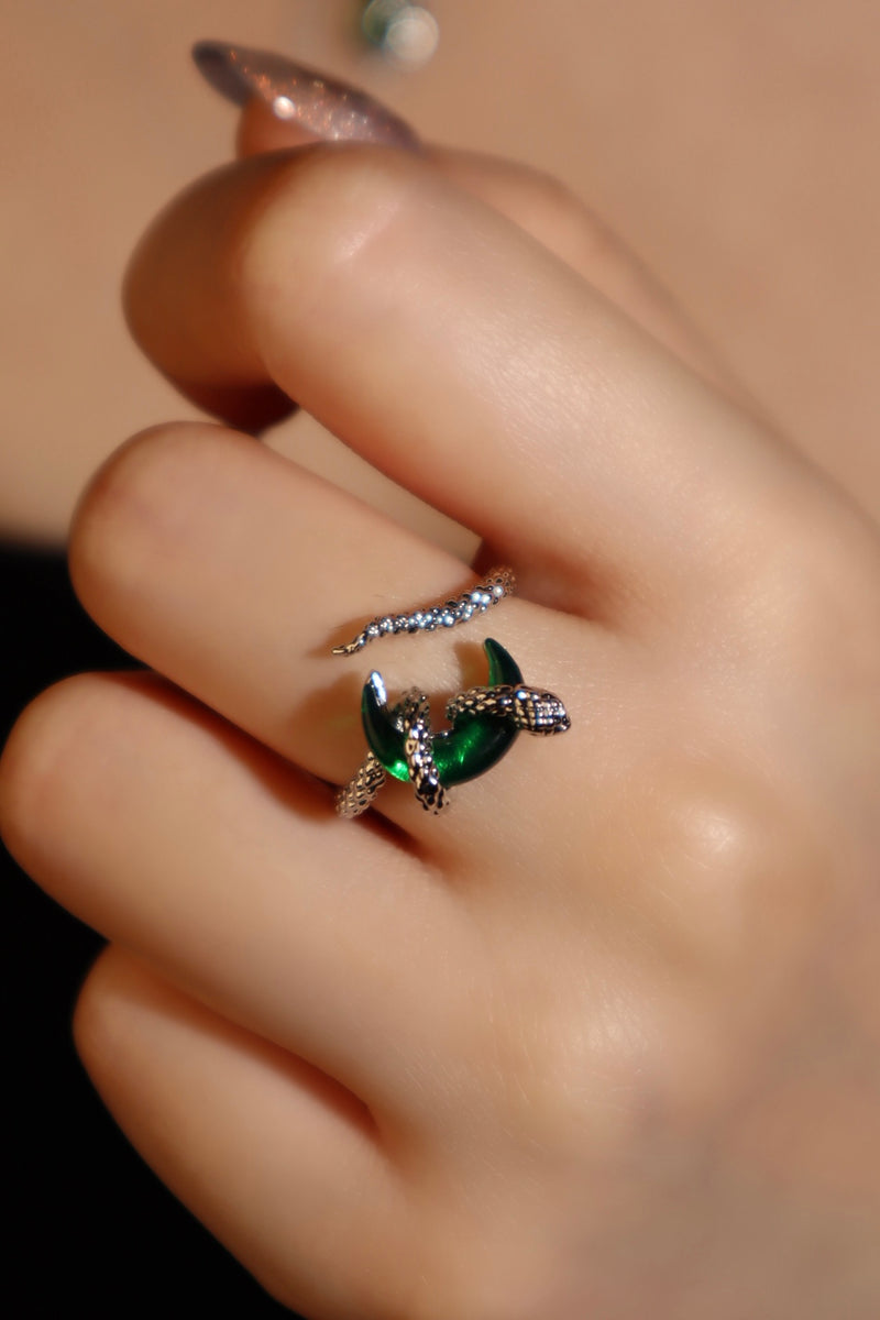 Silver-plated snake ring wrapped around a green zirconia moonstone, adjustable band