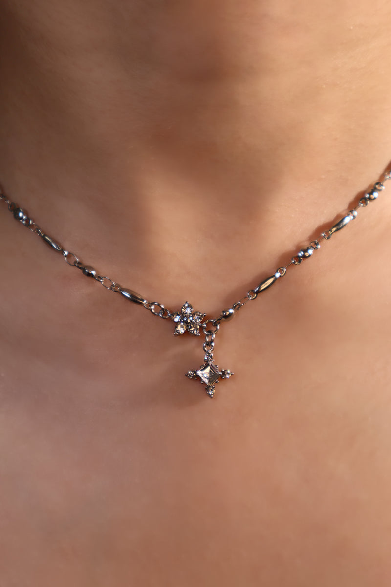 Stainless steel cross necklace traced with sparkling zirconia diamonds like scattered starlight