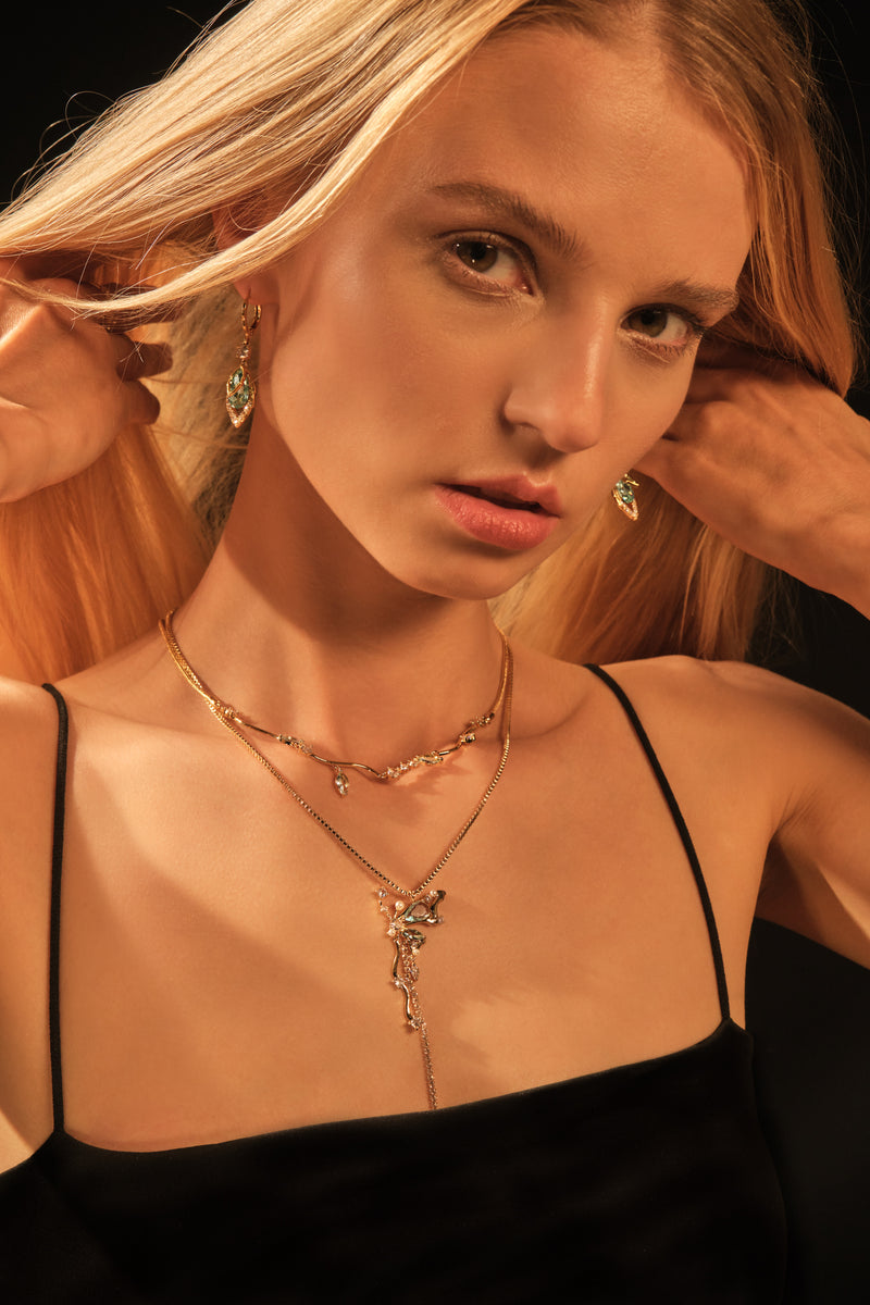 Gold-plated butterfly pendant necklace set with blue cubic zirconia gemstones on a fine chain