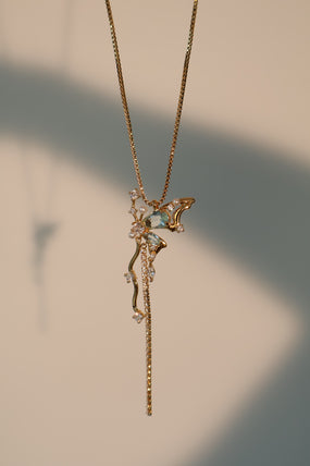Gold-plated butterfly pendant necklace set with blue cubic zirconia gemstones on a fine chain
