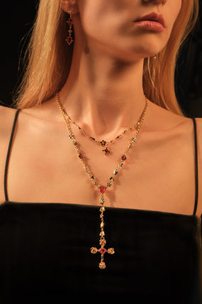 Gold-plated lariat necklace with red gemstones forming a dainty cross pendant