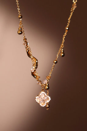 Gold-plated spiral necklace with lucky leaf motif, natural shell pearls and zirconia diamonds