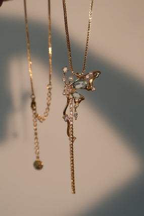 Gold-plated butterfly pendant necklace set with blue cubic zirconia gemstones on a fine chain