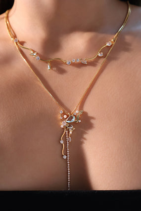 Gold-plated butterfly pendant necklace set with blue cubic zirconia gemstones on a fine chain