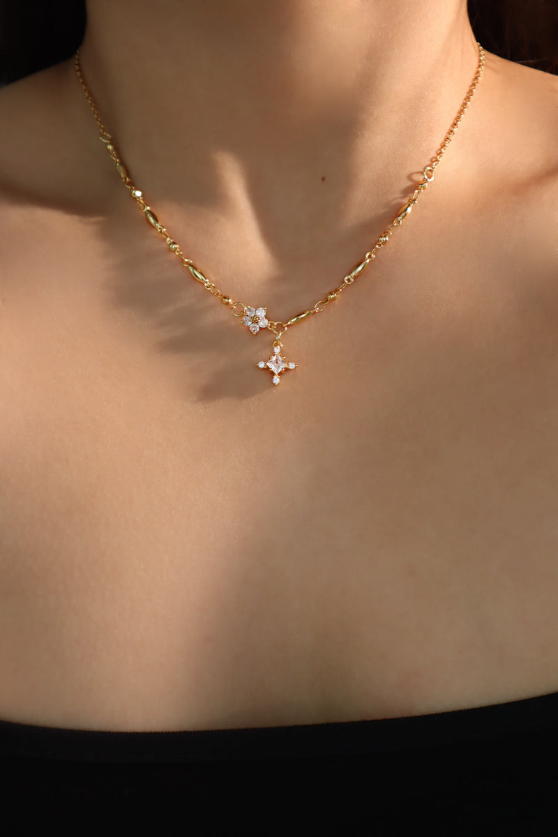 Three gold-plated necklaces with starlight bloom, cross, and shell moon pendants for layering